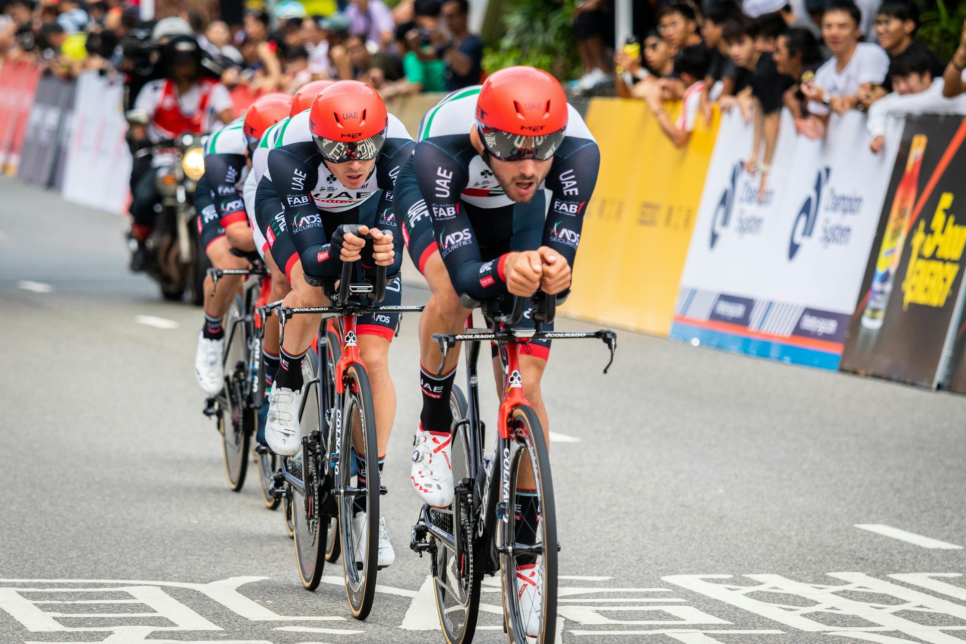 Professional cycling team competing in an outdoor race in Hong Kong, showcasing endurance and teamwork.