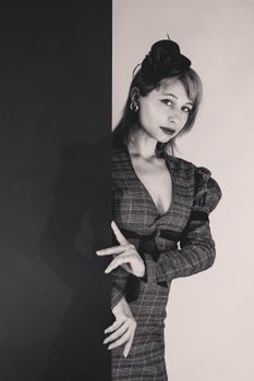 Portrait of a stylish woman in vintage attire with a captivating look, black and white image.