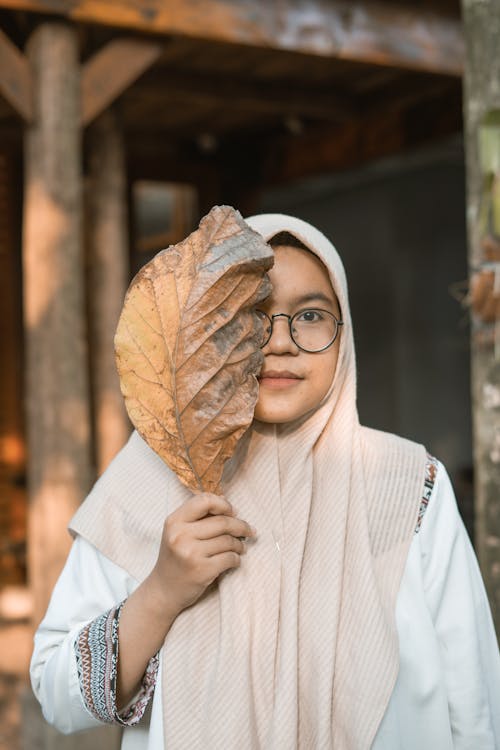 Gratis stockfoto met bedekkend gezicht, blad, half gezicht