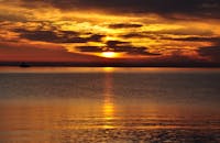 格丁尼亚宁静的海面上，金色的倒影捕捉了戏剧性的日落