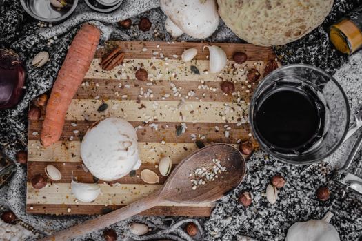 A rustic flat lay of assorted kitchen ingredients on a wooden board, perfect for culinary themes.