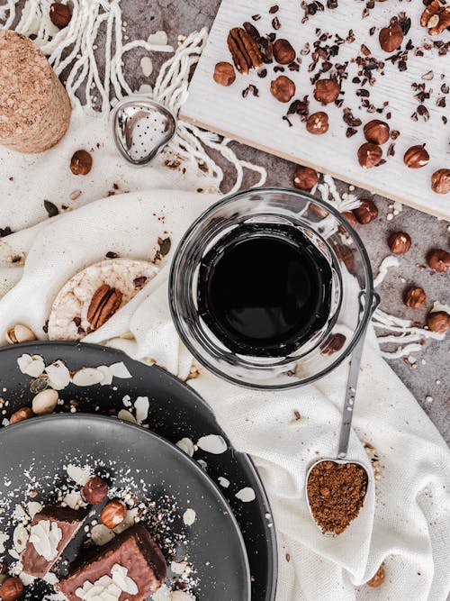 Clear Drinking Glass with Black Liquid on a Messy Kitchen Table