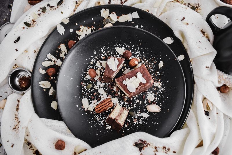 Stylish dessert with nuts on black ceramic plates for a modern culinary presentation.
