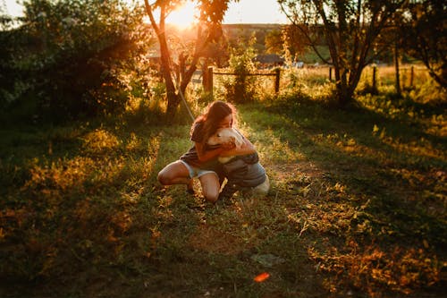 Girl sitting on green grass with Golden Retriever