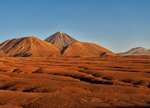 Free Stunning landscape showcasing the Licancabur Volcano with arid terrain under a clear blue sky in the Atacama Desert. Stock Photo