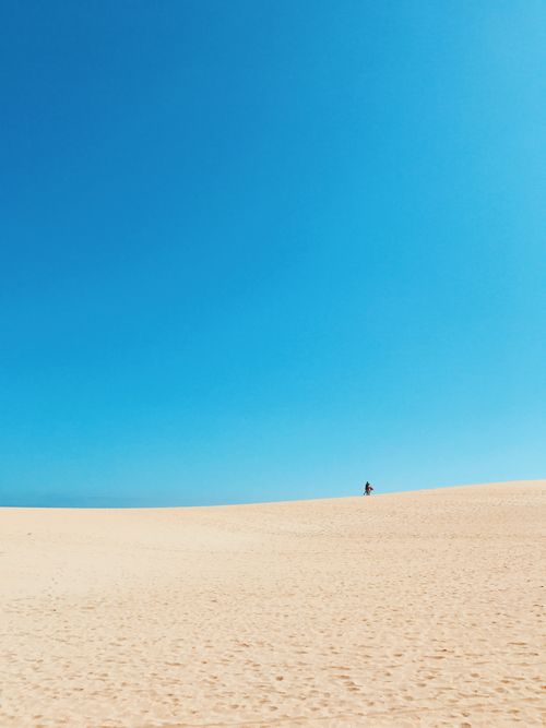 Free Expansive desert landscape under a clear blue sky in La Oliva, Spain. Perfect for travel and adventure themes. Stock Photo