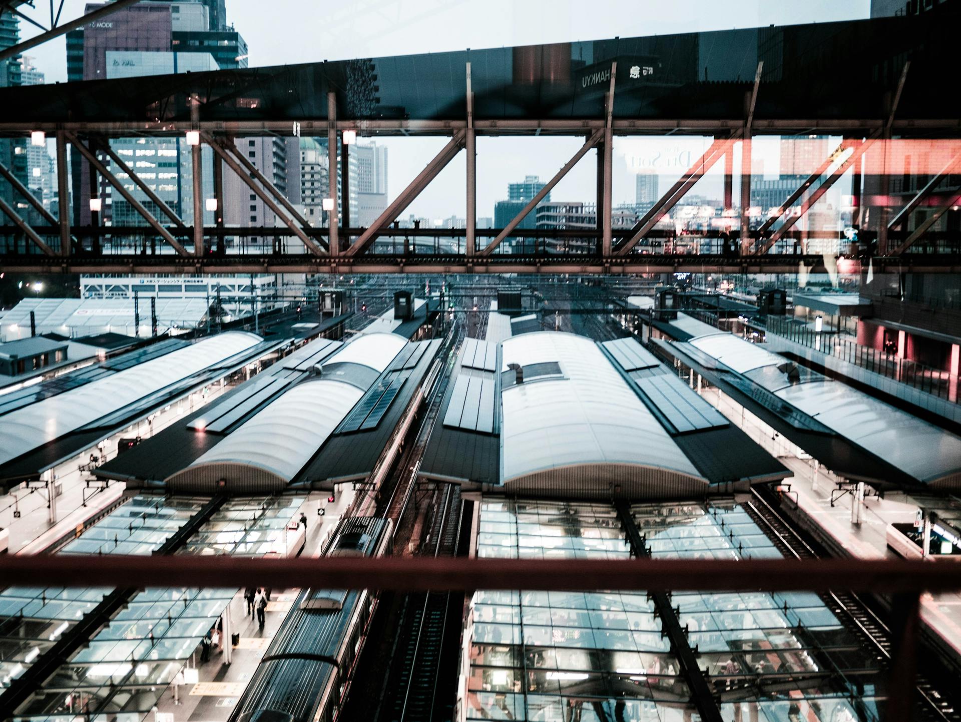 High angle view of a modern urban train station showcasing architectural details and cityscape.