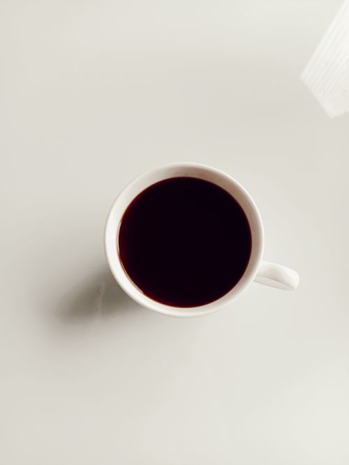 Free Simple overhead shot of a coffee cup on white surface, perfect for minimalist themes. Stock Photo