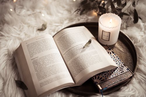 Free Open Book, a Candle and a Notebook on the Tray  Stock Photo