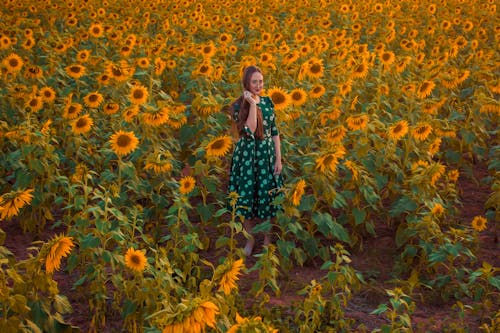 Woman Standing in a Sunflower Field 