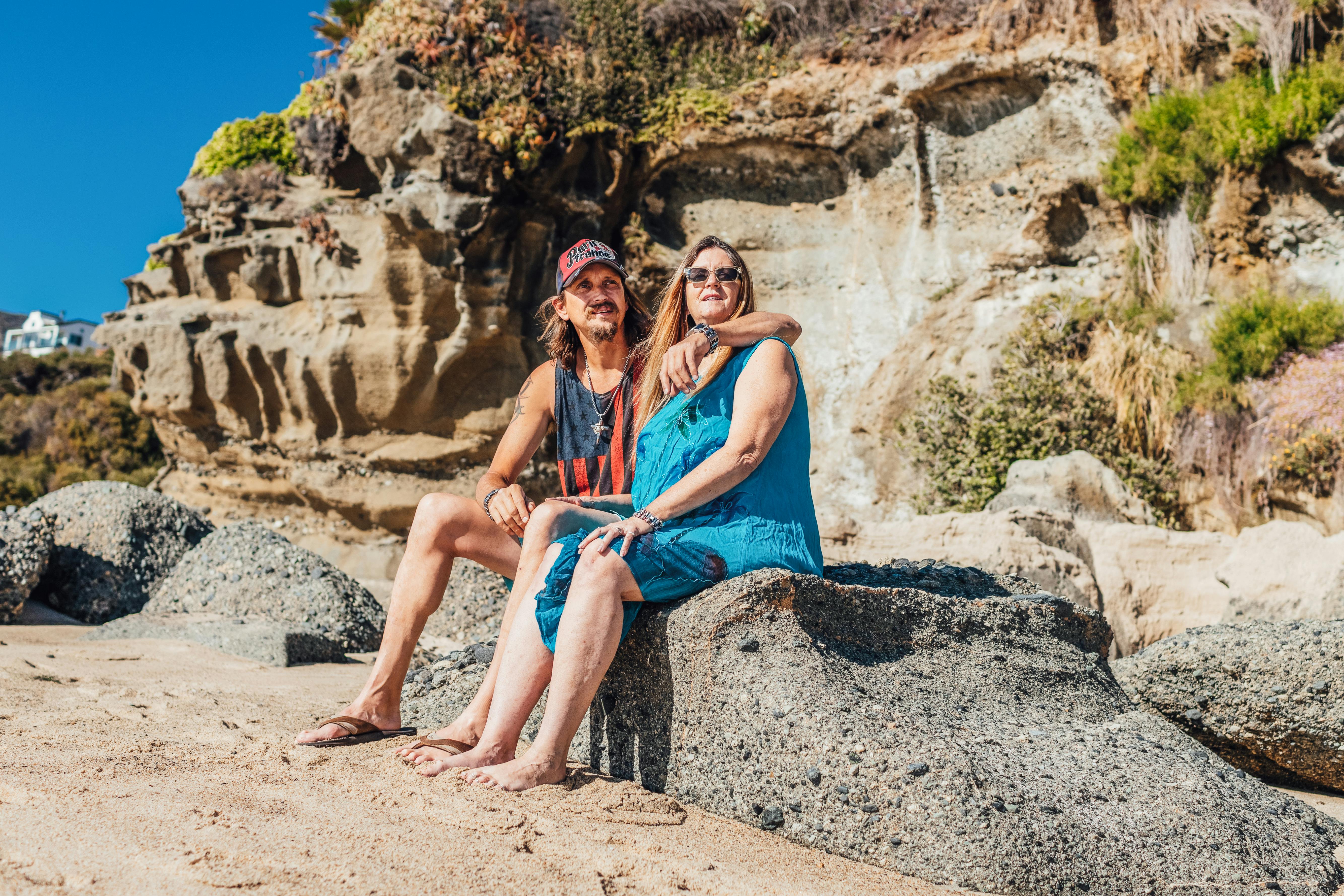 woman in blue sleeveless dress sitting on rock