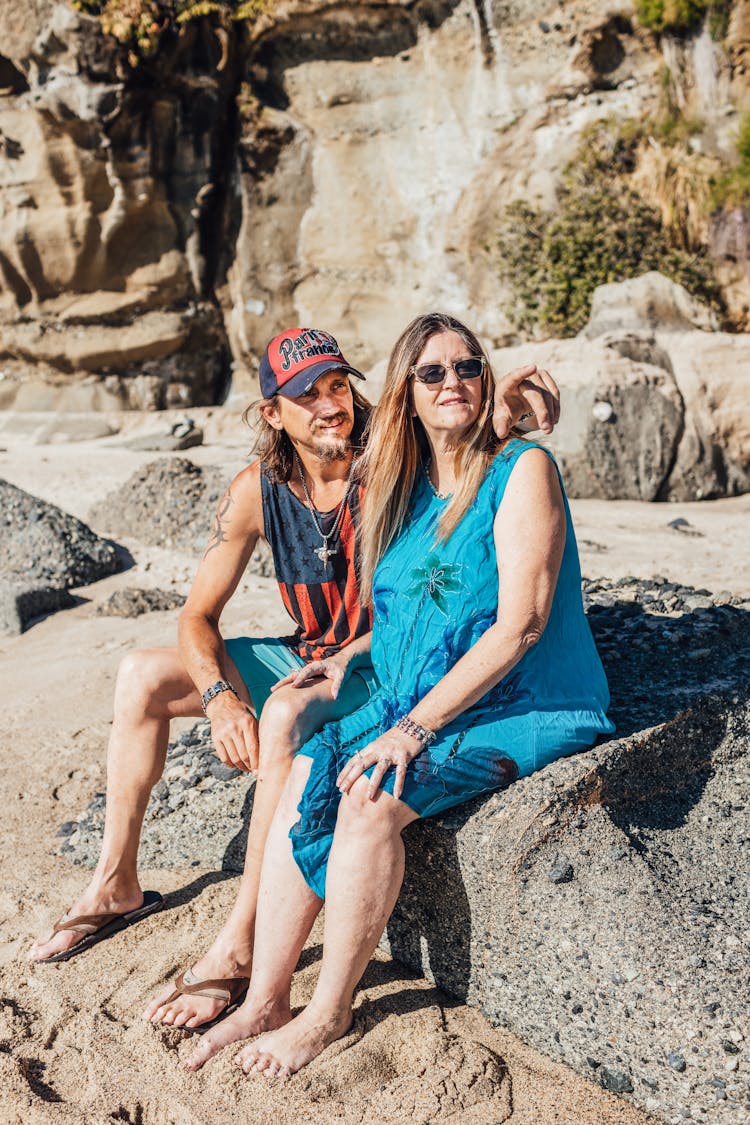 Man And Woman Sitting On Gray Rock