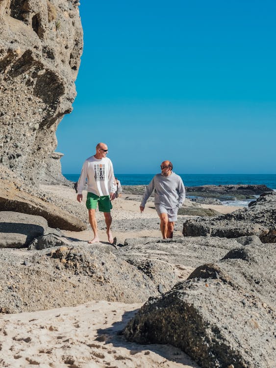 Two Men Walking on the Rocky Shore 