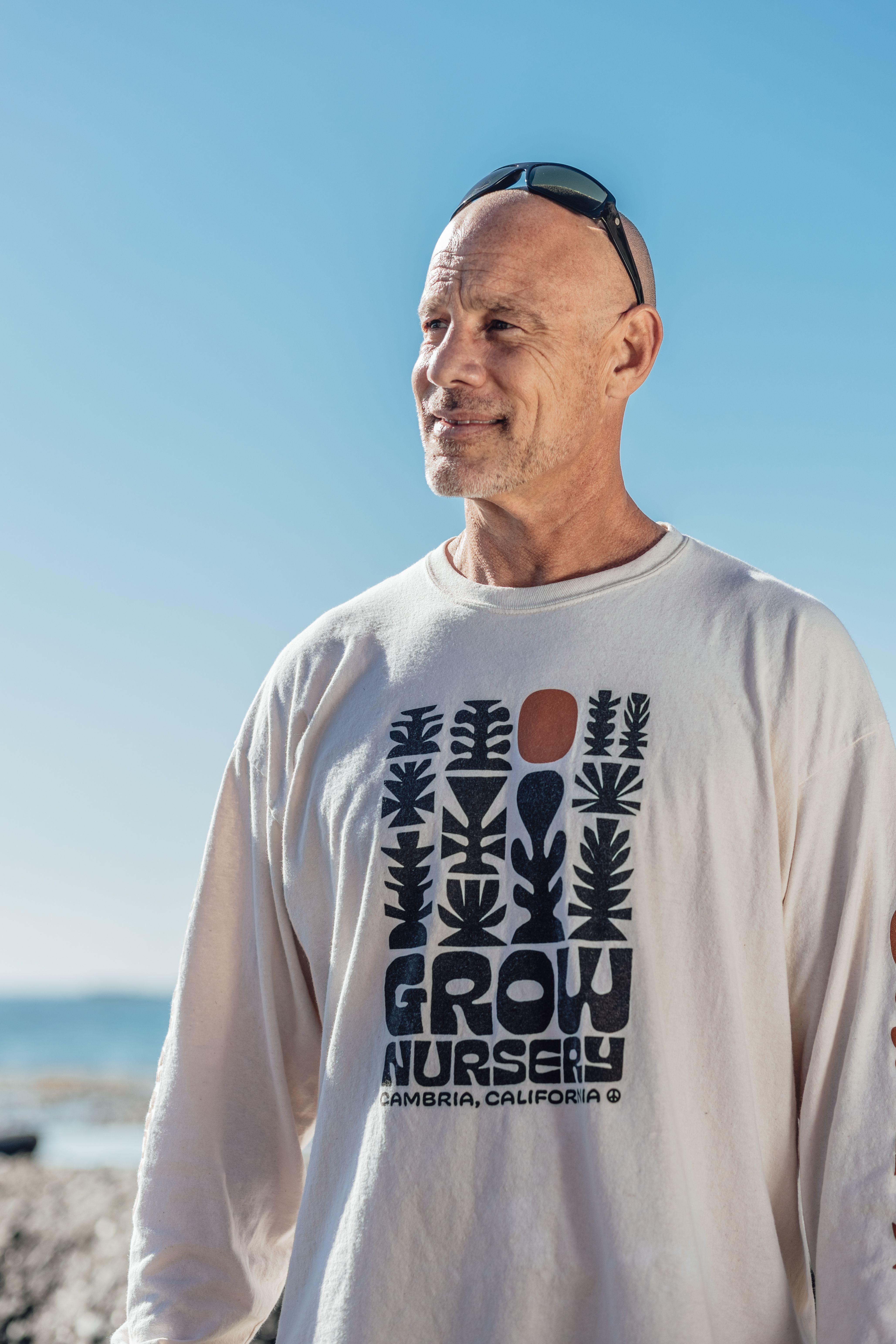 Senior adult man in a graphic shirt enjoying a sunny day at the beach.