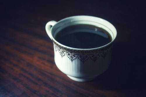 Free Coffee Served in White Teacup on Brown Wooden Surface Stock Photo