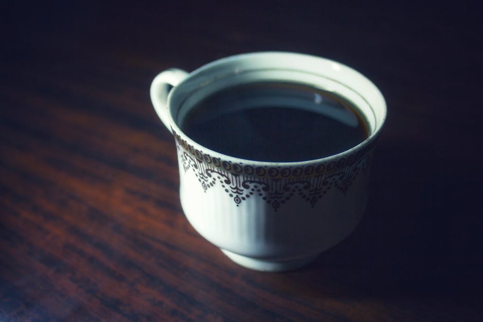 Close-up of a hot cup of black coffee served in an elegant porcelain cup.