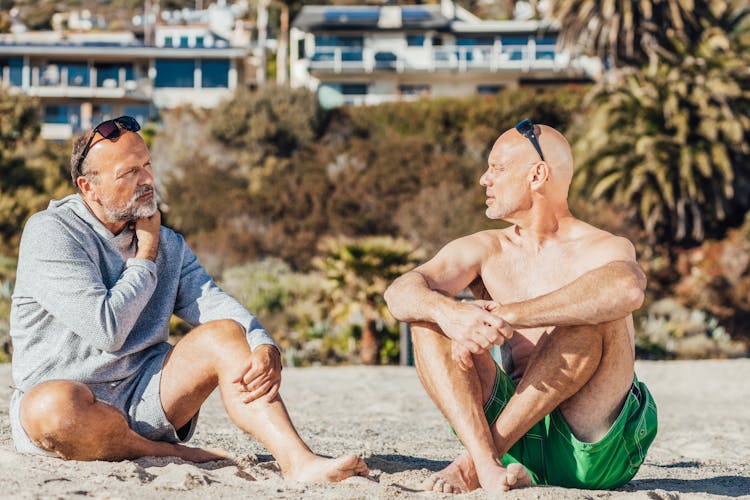 Two Men Talking Together On The Beach