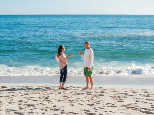 Free Man and Woman Talking at the Beach Stock Photo