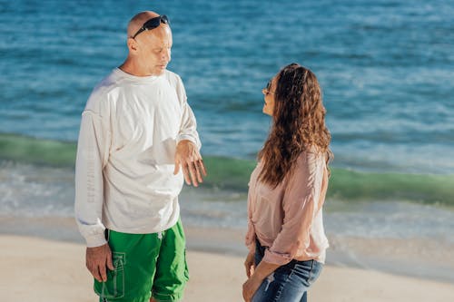 Free Man in White Long Sleeve Shirt Talking to a Woman Stock Photo