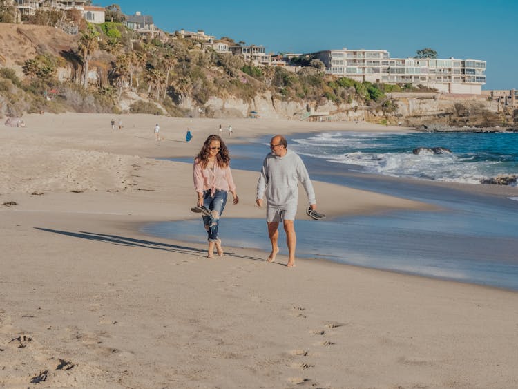 Man And Woman Walking On The Beach Together 