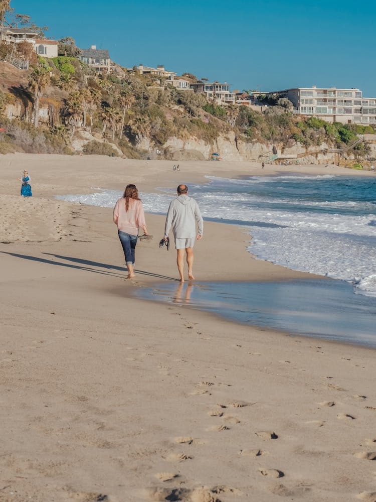 Senior Couple Walking On Seashore