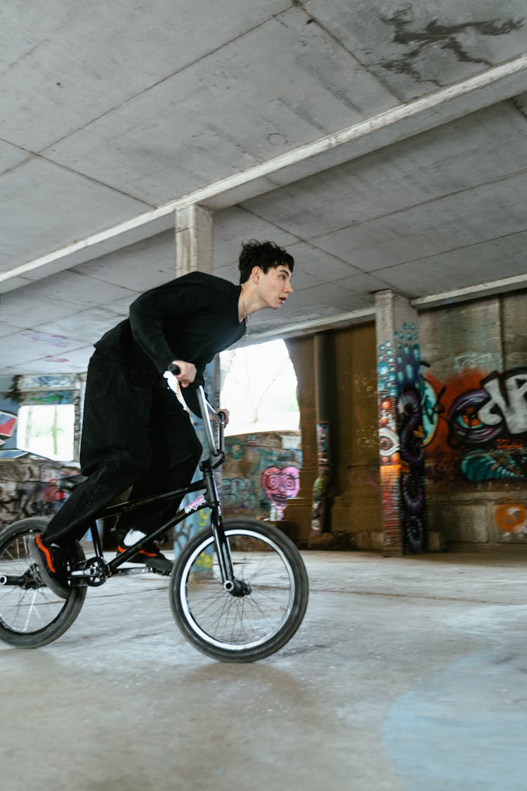 A Man In Black Long Sleeves Riding A Bike