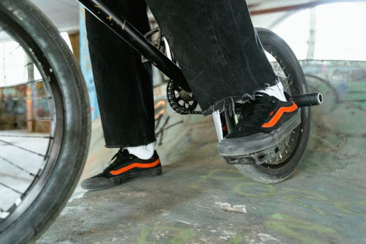 Close-up of a BMX rider performing a trick at an indoor skatepark, showcasing style.