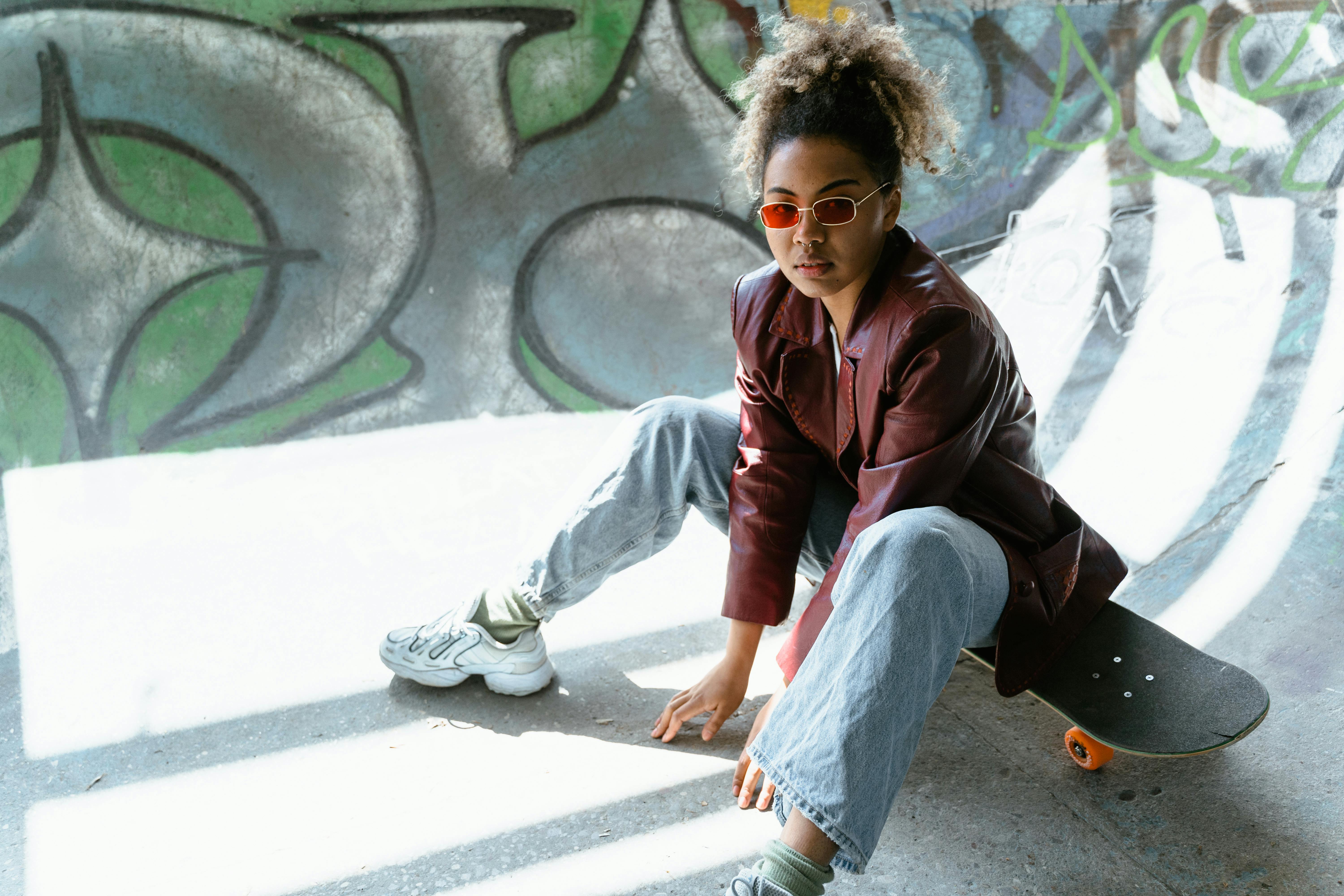 Young Girl in Red Leather Jacket Sitting on a Skateboard on Ramp · Free