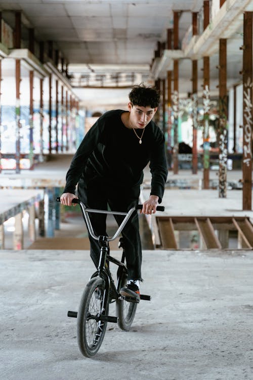 Man in Black Long Sleeves and Pants Riding BMX Bike 