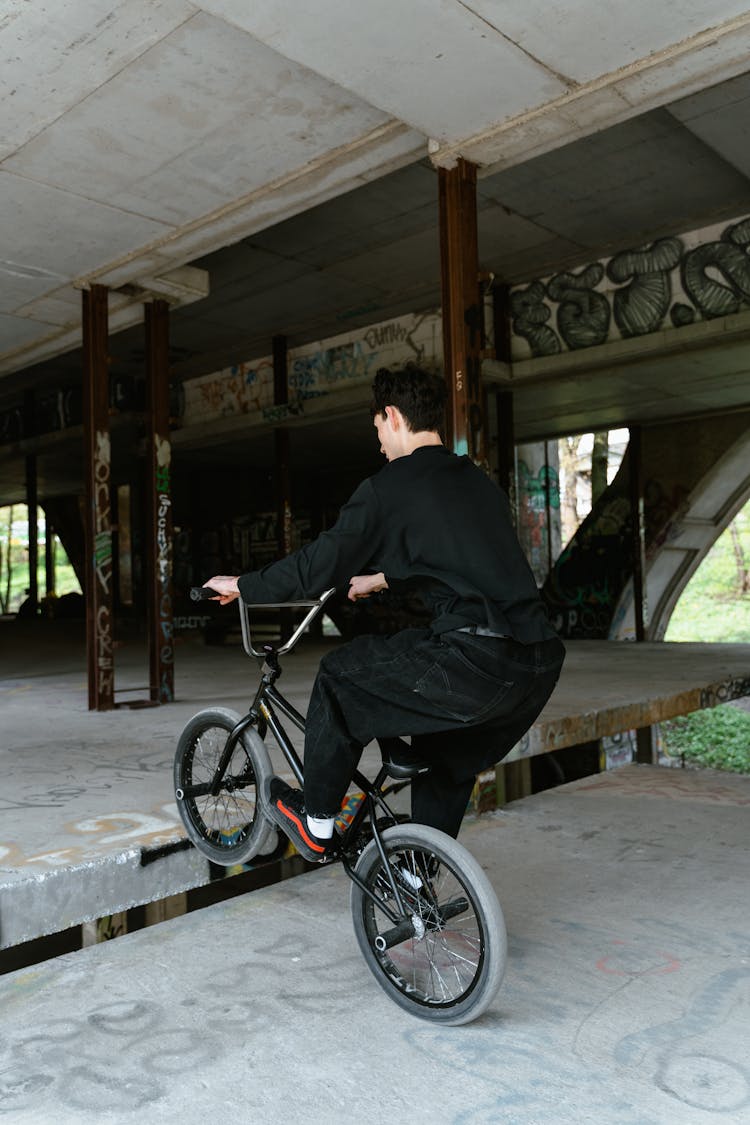 Man In Black Clothes Doing Tricks On BMX Bike 