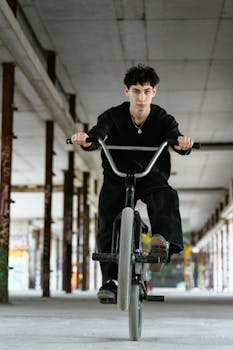 Young man performing BMX stunt in an indoor urban setting with a focus on balance.