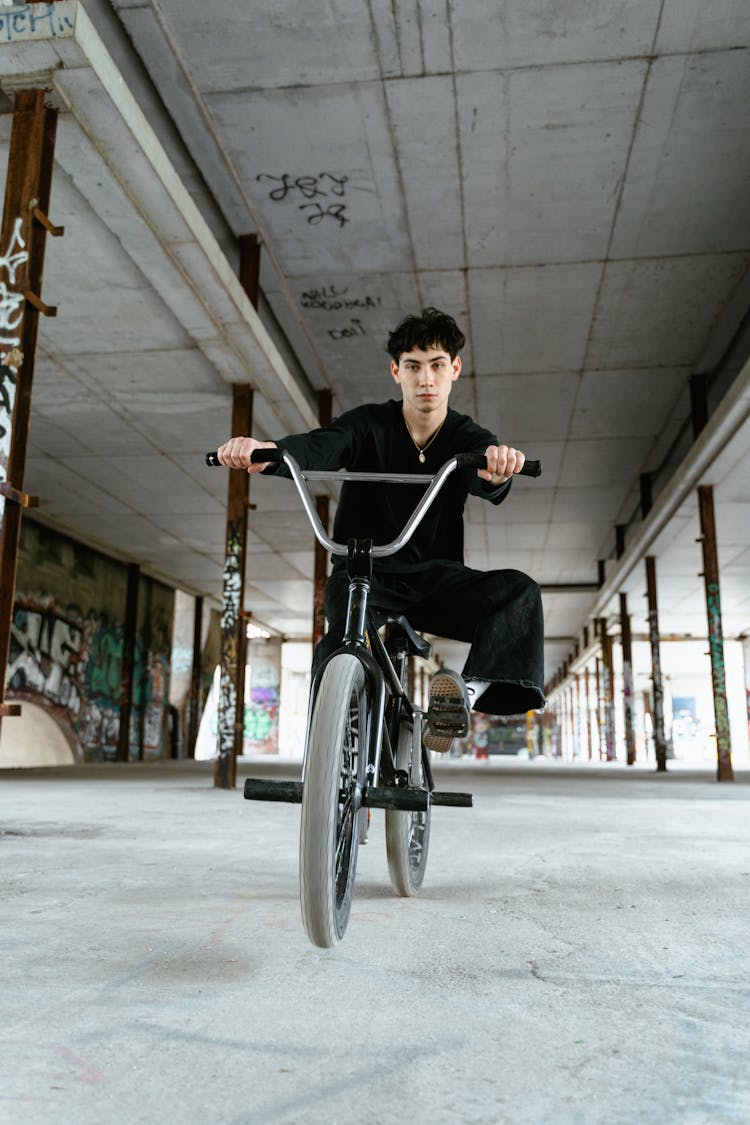 A Man In Black Sweater Riding A Bike