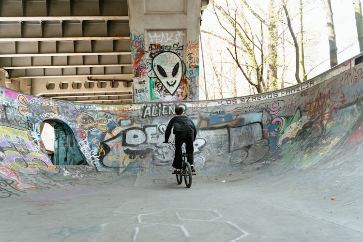 A Back View Of A Man Riding A Bike