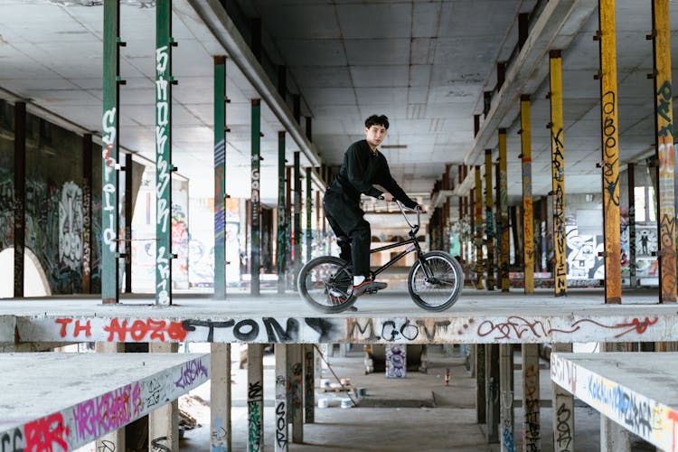 A Man In Black Pants Riding His Bike