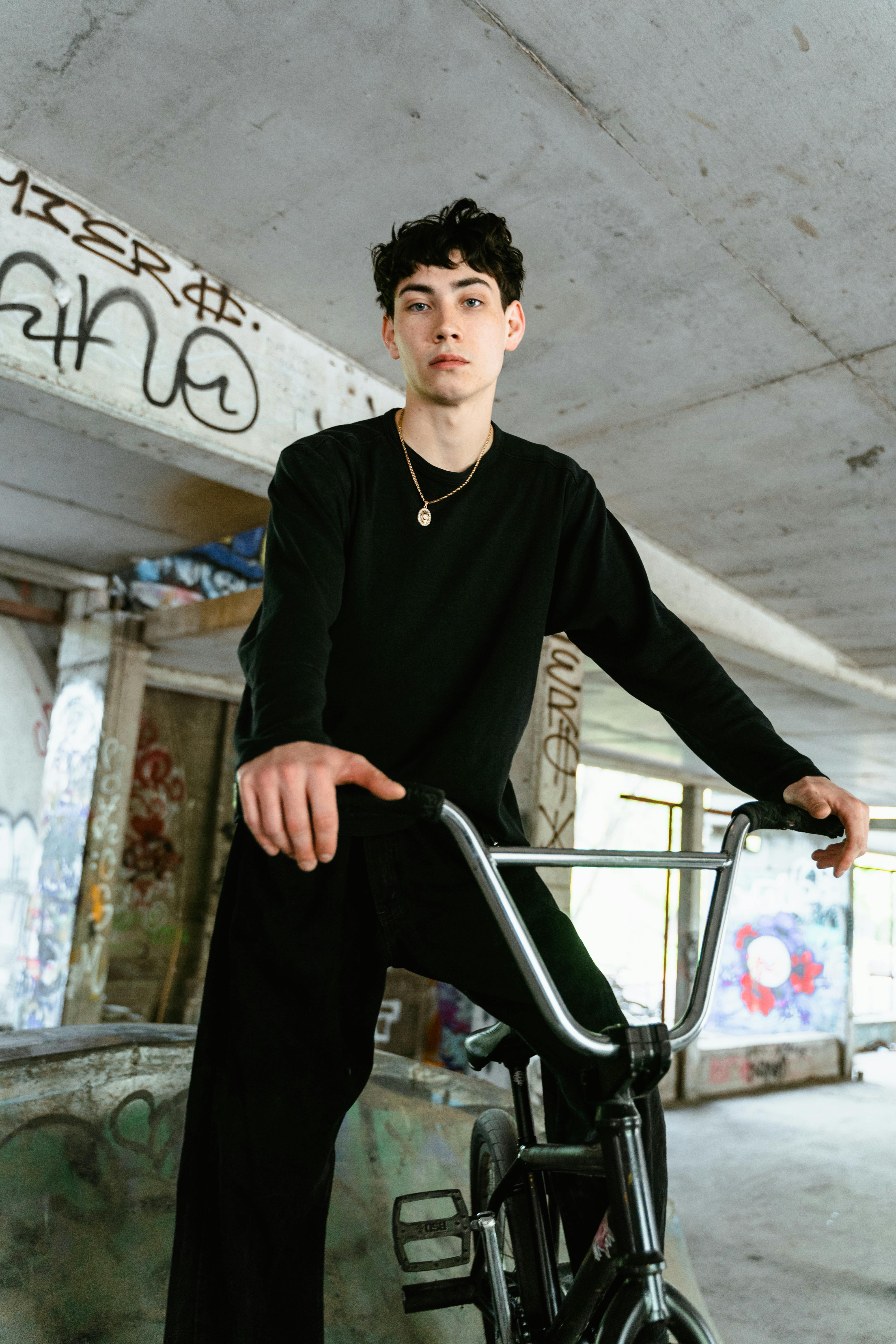 man in black sweater and black pants riding his bicycle