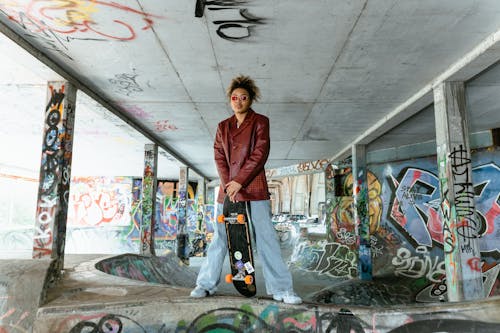 A Woman in Leather Jacket Holding a Skateboard
