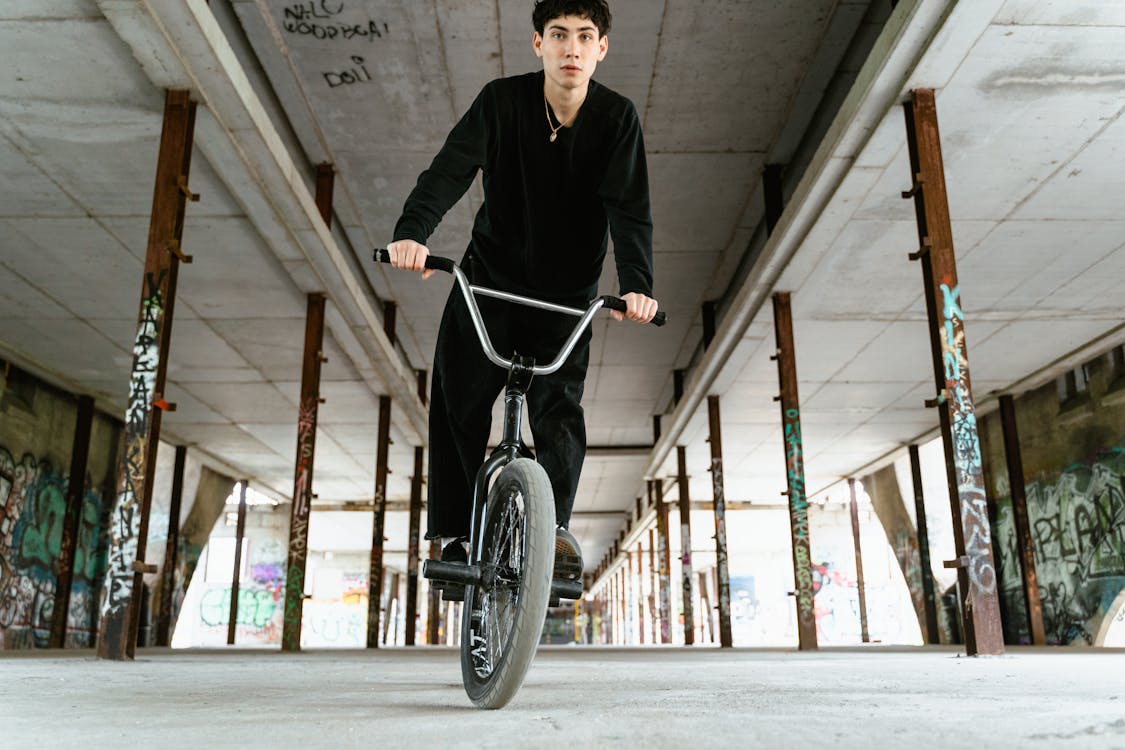 A Man in a Black Outfit Riding His BMX Bicycle · Free Stock Photo