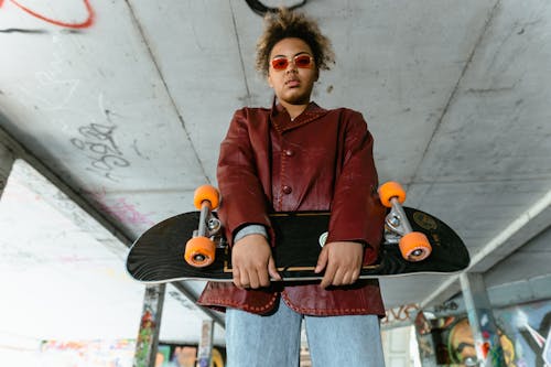 Woman in Red Coat Holding a Skateboard
