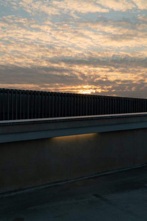 Clouds over Wall in Shadow at Sunset