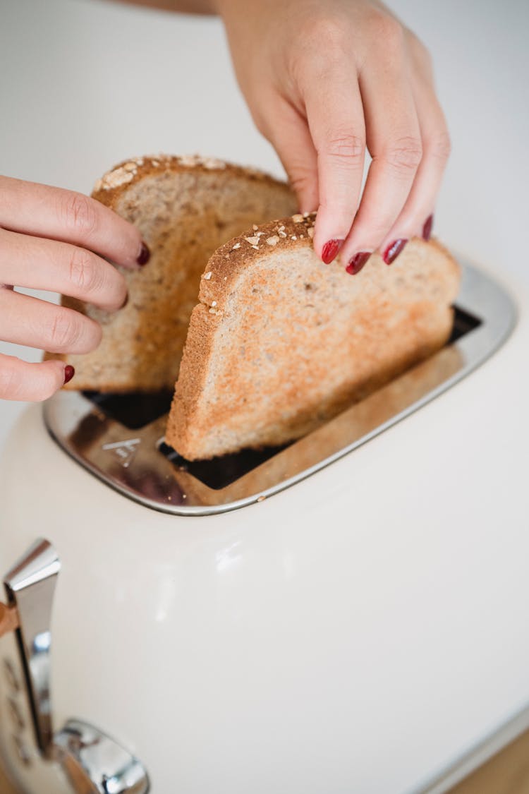 Female Hands Putting Bread To Toaster