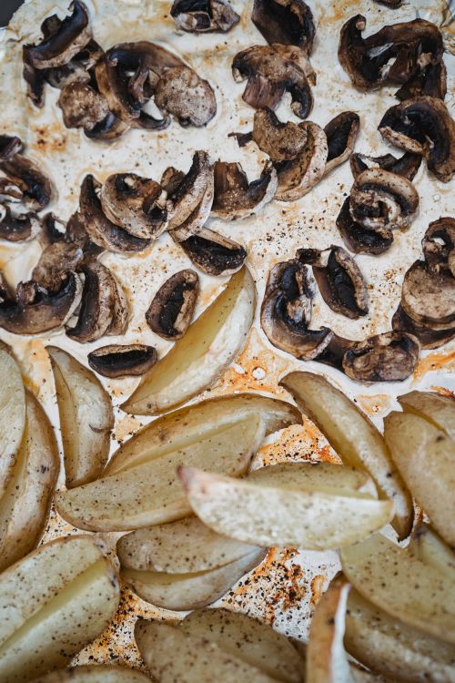 Free Delicious roasted mushrooms and potato wedges, perfect for a hearty meal. Stock Photo