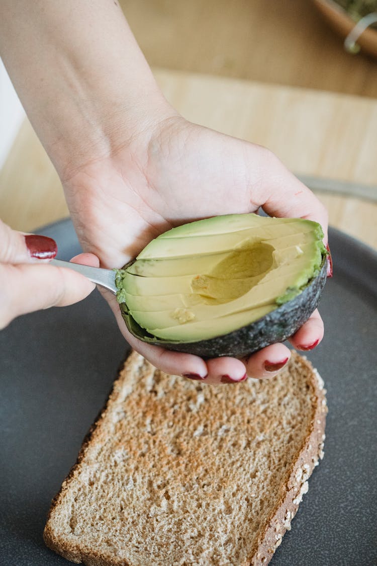 Close-up Of Woman Cutting An Avocado