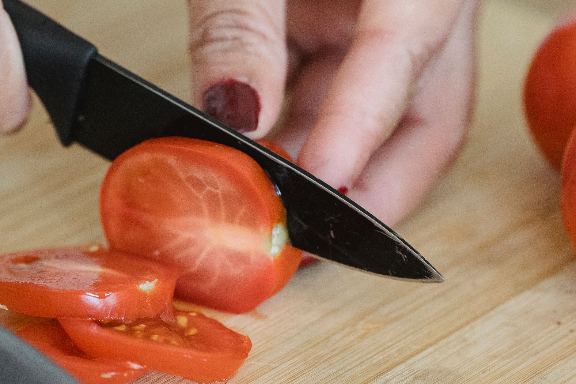Slicing fresh tomatoes with serrated knife