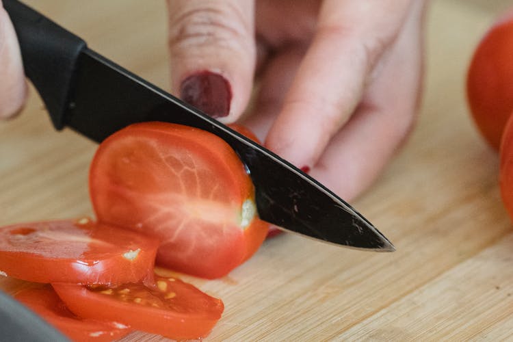 Female Hands Cutting Tomatoes