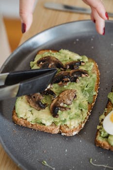 Delicious avocado toast topped with mushrooms served on a plate.
