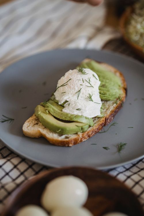 Free Savor a healthy and gourmet avocado toast topped with ricotta cheese on a fresh slice of bread. Stock Photo