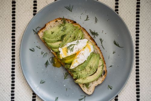 Free Elegant avocado toast with poached egg and fresh dill on gray plate, perfect for gourmet breakfast. Stock Photo