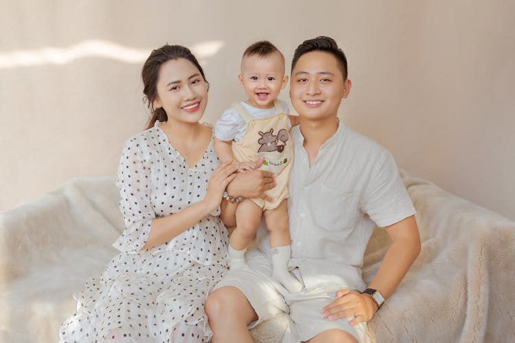 Happy Ethnic Family With Kid On Sofa