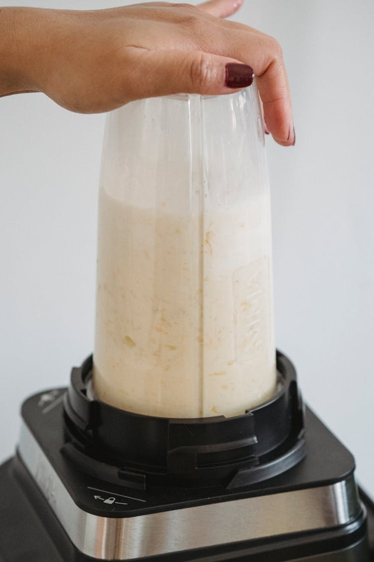 A Person Making Smoothie Using Blender