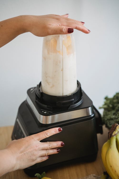 Free A Person Making Smoothie Using Blender Stock Photo